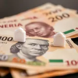 Illustration of Nigerian currency notes with digital banking icons symbolizing fund withdrawal constraints